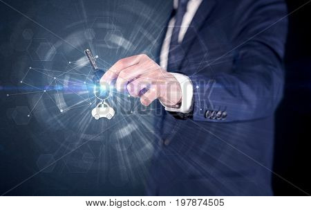 Businessman in suit holding over a key with connection concept around