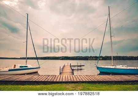 Boats on the water. Wooden pier on the lake.