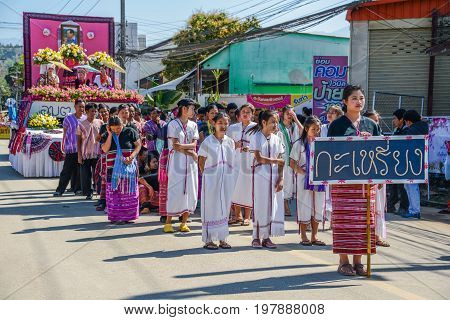 CHIANGMAI THAILAND - JANUARY 25 2015: Hill Tribe people with traditional costume holding board of Karen nationality name in parade of 22nd Traditional Skirt Fabric and The Indigenous Product and Culture Festival in Mae Chaem Chiangmai Thailand