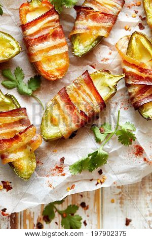Jalapeno poppers wrapped in bacon stuffed with cheese seasoned with herbs and spices, top view