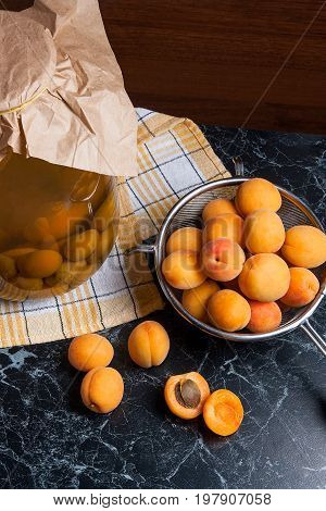 Fresh Organic Harvested Apricots In Steel Colander And Big Glass Jar With Canned Apricot Compote On