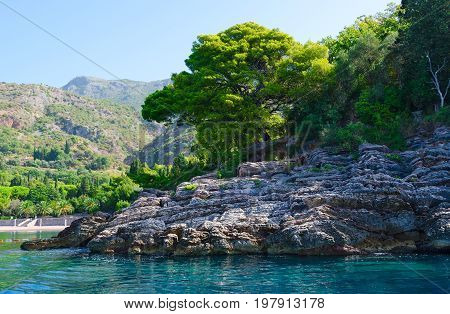 View from sea to picturesque rocky coast near famous Royal beach Milocer Montenegro