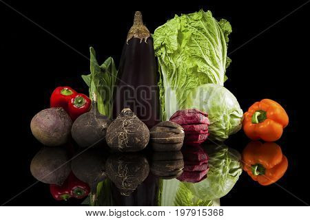 Luxurious colorful fresh vegetable isolated on black background. Beet capsicum cabbage chinese cabbage fennel black radish and eggplant. Fresh healthy eating.