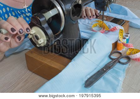processes of sewing on the sewing machine sew women's hands sewing machine. Female tailor threading leather material on sewing machine