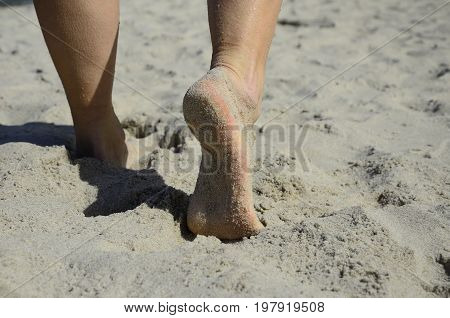 woman which is walking on the sand beach