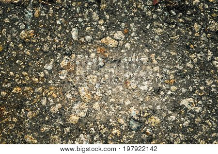 Dark stone background. Texture of pebbles with vignette.