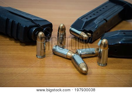 9 mm Pistol, bullets and magazine on wooden background. Gun isolated