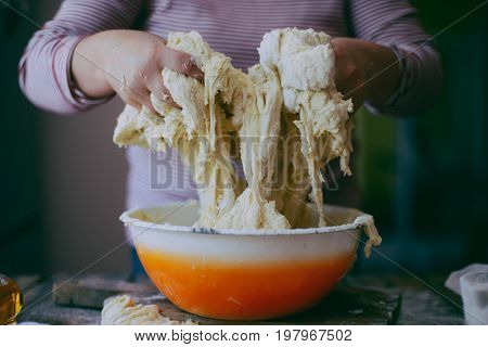 Close Up View Of Baker Kneading Dough. Homemade Bread. Hands Preparing Bread Dough On Wooden Table.