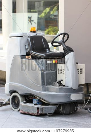 Empty Automatic Scrubber Machine Parked Beside Big Pole