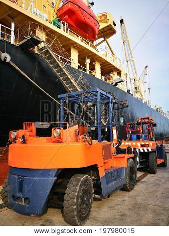 Forklift Truck Lifting Cargo Container In Dock Yard