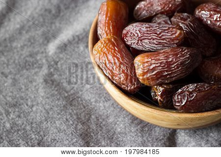 Fresh Dates Medjool In Wooden Bowl In Upper Right Corner, On Dark Grey Background. Selective Focus.
