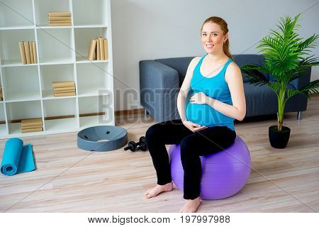 Pregnant woman doing pre-natal exercises at home