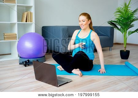 Pregnant woman doing physical exercises at home