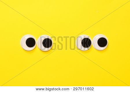 Googly Eyes Of A Quarreling Pair Of Lovers On Yellow Background. Mad Funny Toys Eyes Close Up.
