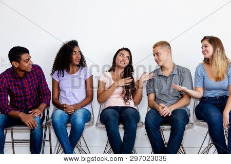 Talking Young Adult Group Of People In Waiting Room At Hospital