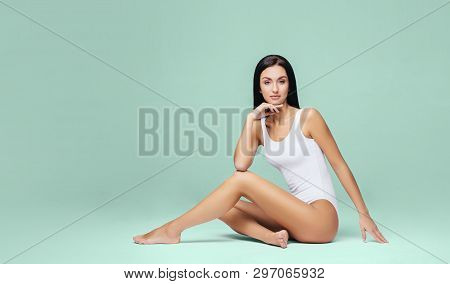 Athletic And Healthy Girl Posing In White Bodysuit. Fit And Sexy Woman In Underwear Swimsuit. Slim S