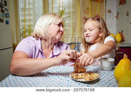 Kirov, Russia - November 04, 2018: Adalt Mother And Her Young Daughter In A Kitchen With Pancakes