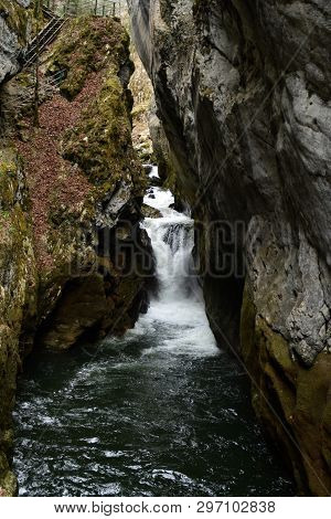 Waterfall In A Narrow River In Switzerland