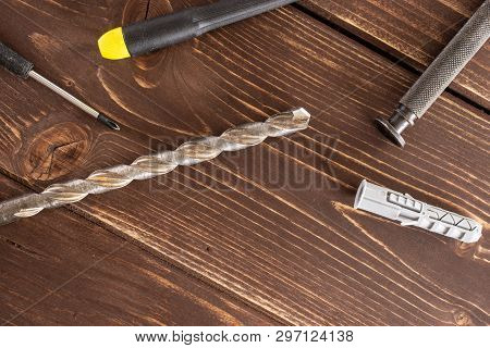 Lot Of Whole Work Item Drill, Screwdrivers And Wall Plug Flatlay On Brown Wood