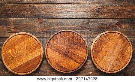 Kitchen Concept. Rustic Background. Flat Lay Of Three Empty Wooden Round Pizza Boards On Table. Copy