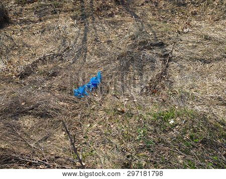 Blue Plastic Garbage Bag Lying On The Ground In A Forest Clearing Polluting The Forest