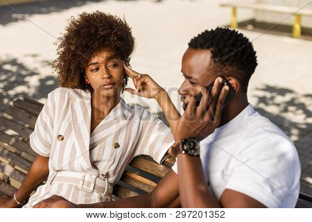 Outdoor Protrait Of Black African American Couple -  Girl Bored Watcing Boyfriend On Phone
