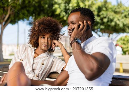 Outdoor Protrait Of Black African American Couple -  Girl Bored Watcing Boyfriend On Phone