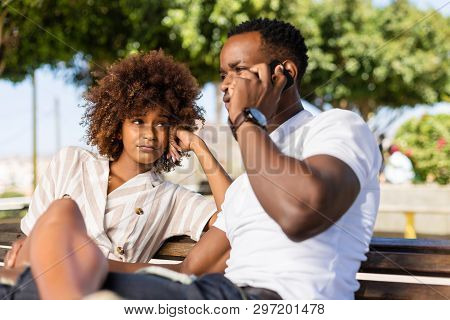 Outdoor Protrait Of Black African American Couple -  Girl Bored Watcing Boyfriend On Phone