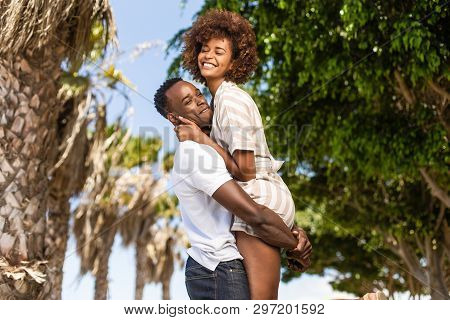 Outdoor Protrait Of Black African American Couple - Guy Carrying Girfriend On His Back