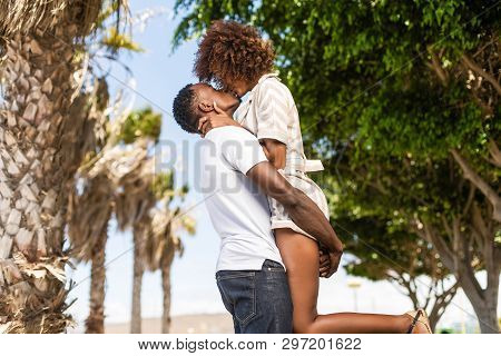 Outdoor Protrait Of Black African American Couple - Guy Carrying Girfriend On His Back