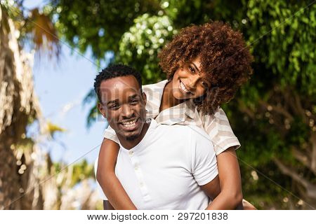 Outdoor Protrait Of Black African American Couple - Guy Carrying Girfriend On His Back