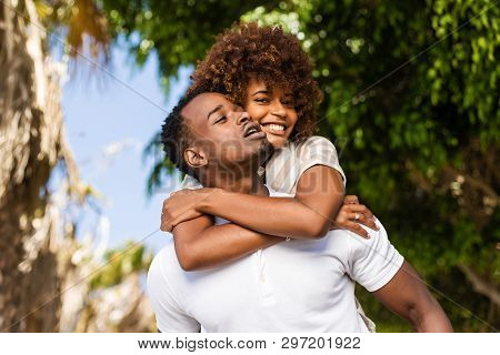 Outdoor Protrait Of Black African American Couple - Guy Carrying Girfriend On His Back