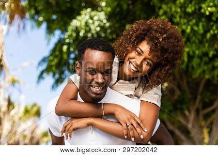 Outdoor Protrait Of Black African American Couple - Guy Carrying Girfriend On His Back
