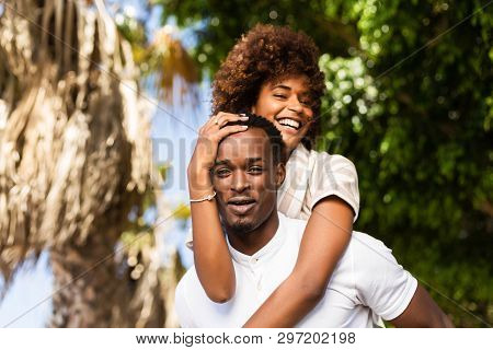 Outdoor Protrait Of Black African American Couple - Guy Carrying Girfriend On His Back
