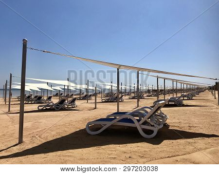 Stylish Lounger In Yellow Sand To Sun Sunbed On Beach In Summer Under Open Sky. Sunbed Intended For 