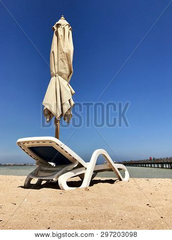 Stylish Lounger In Yellow Sand To Sun Sunbed On Beach In Summer Under Open Sky. Sunbed Intended For 