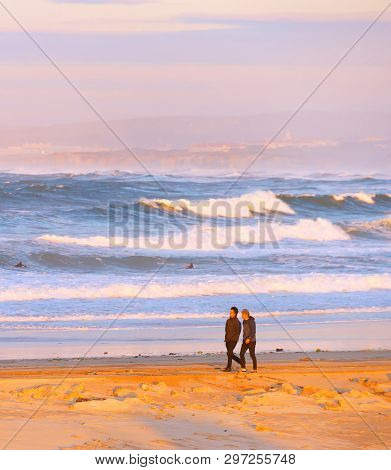 Peniche, Portugal - December 17, 2016: Young People Walking By Thebeach Of Atlantic Ocean Coast In S