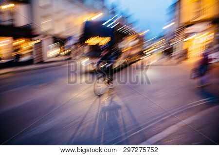 Abstract Defocused Light-trails Of Fast Cyclist Silhouette Delivering Food Ordered Through Mobile Ap