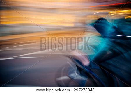 Front View Of Abstract Defocused Light-trails  Of Fast Cyclist Silhouette Delivering Food Through Mo