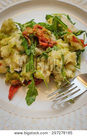 Homemade Italian Potato Gnocchi In Pesto Sauce With Arugula And Sundried Tomatoes