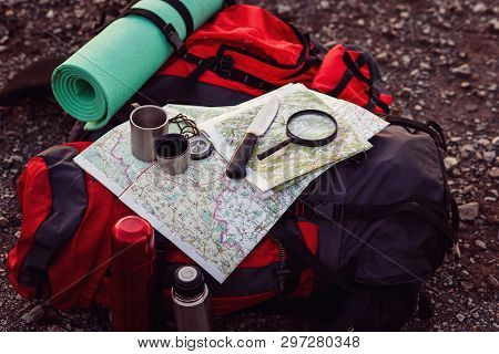 Close Up Shot Of Travel Equipment, Backpack, Map, Compass, Knife, Sleeping Pad On The Ground At Moun