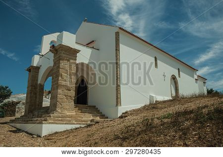 Unusual Entrance Church With Two Big Stone Columns And Steps, In The Cobblestone Main Street Of Evor