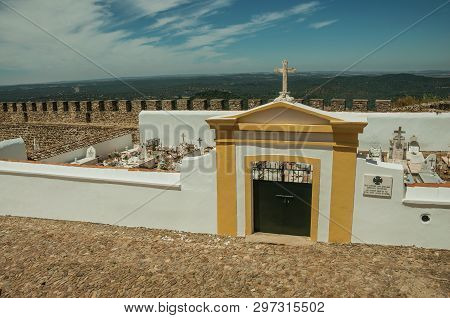 Evoramonte, Portugal - July 6, 2018. Colorful gateway in graveyard wall in the main street of Evoramonte. A tiny fortified civil parish over hill where stands out its historic castle in Portugal.