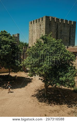 Elvas, Portugal - July 07, 2018. Woman walking on a sunny day through the central courtyard at the Castle of Elvas. A gracious star-shaped fortress city on the easternmost frontier of Portugal.