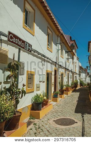 Elvas, Portugal - July 7, 2018. Old colorful houses with flowered vases and signpost indicating the Castle at Elvas. A gracious star-shaped fortress city on the easternmost frontier of Portugal.