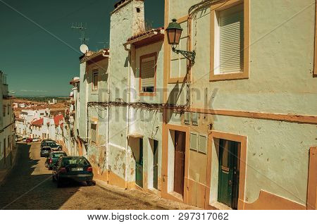 Elvas, Portugal - July 7, 2018. Old colorful houses with peeling plaster wall at Elvas. A gracious star-shaped fortress city on the easternmost frontier of Portugal. Retouched photo.