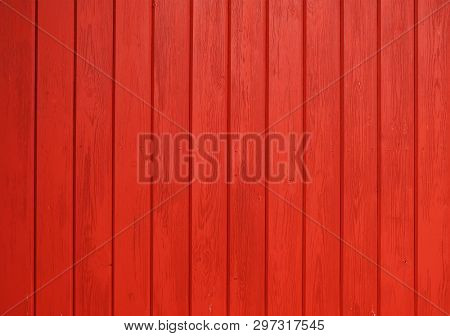 Old wooden background painted with red paint with a texture of cracks and scratches. Red background