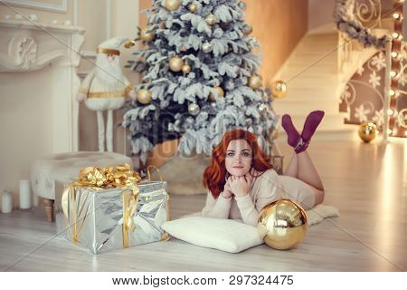 Happy Young Lady With Curlu Hair Gifts By The Fireplace Near The Christmas Tree. New Year Concept.