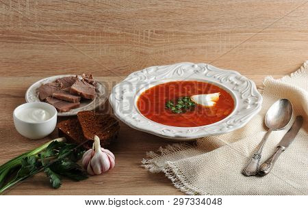 Soup In A Bowl With Dill, Sour Cream, Beef And Black Bread On Wooden Background - Borsh - National D