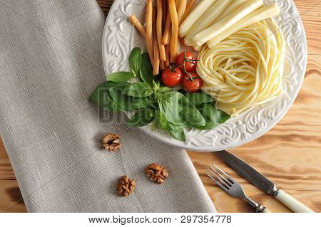 Various Types Of Cheese In A Bowl With Basil And Cherry Tomatoes - Cheese Chechil, Straws, Smoked Ch